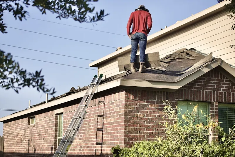 Professional roofer working on a residential roof in Henningers Mill